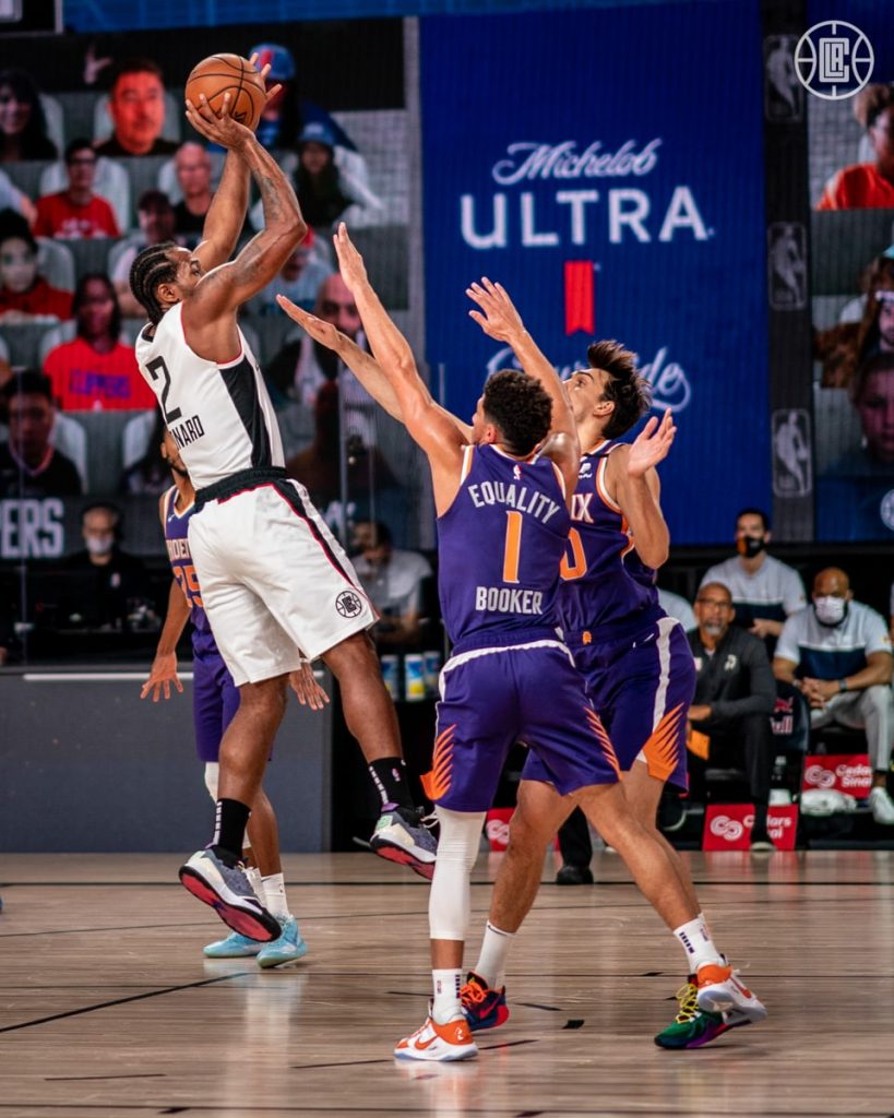 LA Clippers Kawhi Leonard shoots over Phoenix Suns Devin Booker in the NBA's Orlando Bubble
